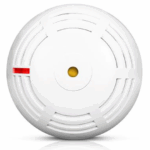 Ein runder, weißer Rauchmelder mit Lüftungsschlitzen und einem roten Indikatorlicht auf der linken Seite.
