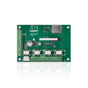 Grüne elektronische Leiterplatte mit der Aufschrift 'Satel abax2 ACX-220', bestückt mit mehreren Anschlussklemmen, einem Rundbauteil und Steckverbindungen, vorgesehen für Sicherheitssysteme.