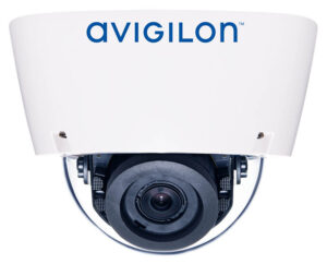 Nahaufnahme einer weißen Überwachungskamera der Marke Avigilon mit sichtbarem Objektiv im unteren Bereich.