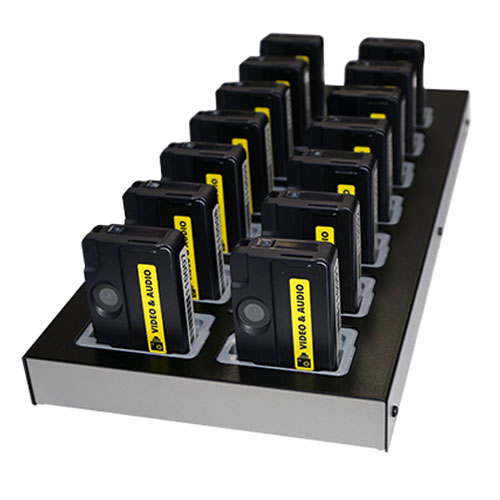 Ein Ladestation mit mehreren Körperkameras, die in ordentlichen Reihen platziert sind, mit gelben Etiketten, auf denen "VIDEO & AUDIO" steht.