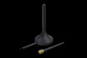 Eine schwarze Antenne mit abgerundetem Sockel und abnehmbarem Kabel, das mit einem goldfarbenen Steckverbinder endet, auf schwarzem Hintergrund.