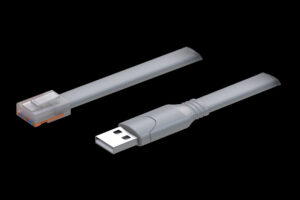 Graues Flachbandkabel mit einem USB-Anschluss an einem Ende und einem RJ45-Anschluss am anderen Ende vor schwarzem Hintergrund.