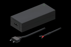 Schwarzes Netzteil mit zwei Kabeln, eines mit einem Netzstecker und das andere mit offenen Drahtenden, auf schwarzem Hintergrund.