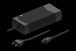 Ein schwarzes Ladegerät mit zwei entfernbaren Kabeln, eines mit einem Eurostecker und das andere mit einem speziellen Steckverbinder, vor einem schwarzen Hintergrund.