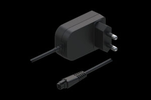 Schwarzes Netzteil mit Eurostecker, daneben ein separates Stromkabel mit rechteckigem Anschluss, dargestellt auf schwarzem Hintergrund.