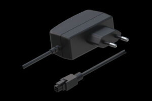Ein schwarzes Netzteil mit zwei runden Steckerkontakten und einem abnehmbaren Kabel mit rechteckigem Anschluss.