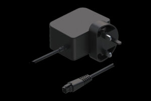 Ein schwarzes Netzteil mit dreipoligem Stecker, geeignet für britische Steckdosen, und einem abnehmbaren Kabel mit rechteckigem Anschluss.