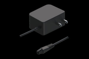 Ein schwarzes Ladegerät mit einem Netzstecker und einem herausziehbaren Kabel auf schwarzem Hintergrund.