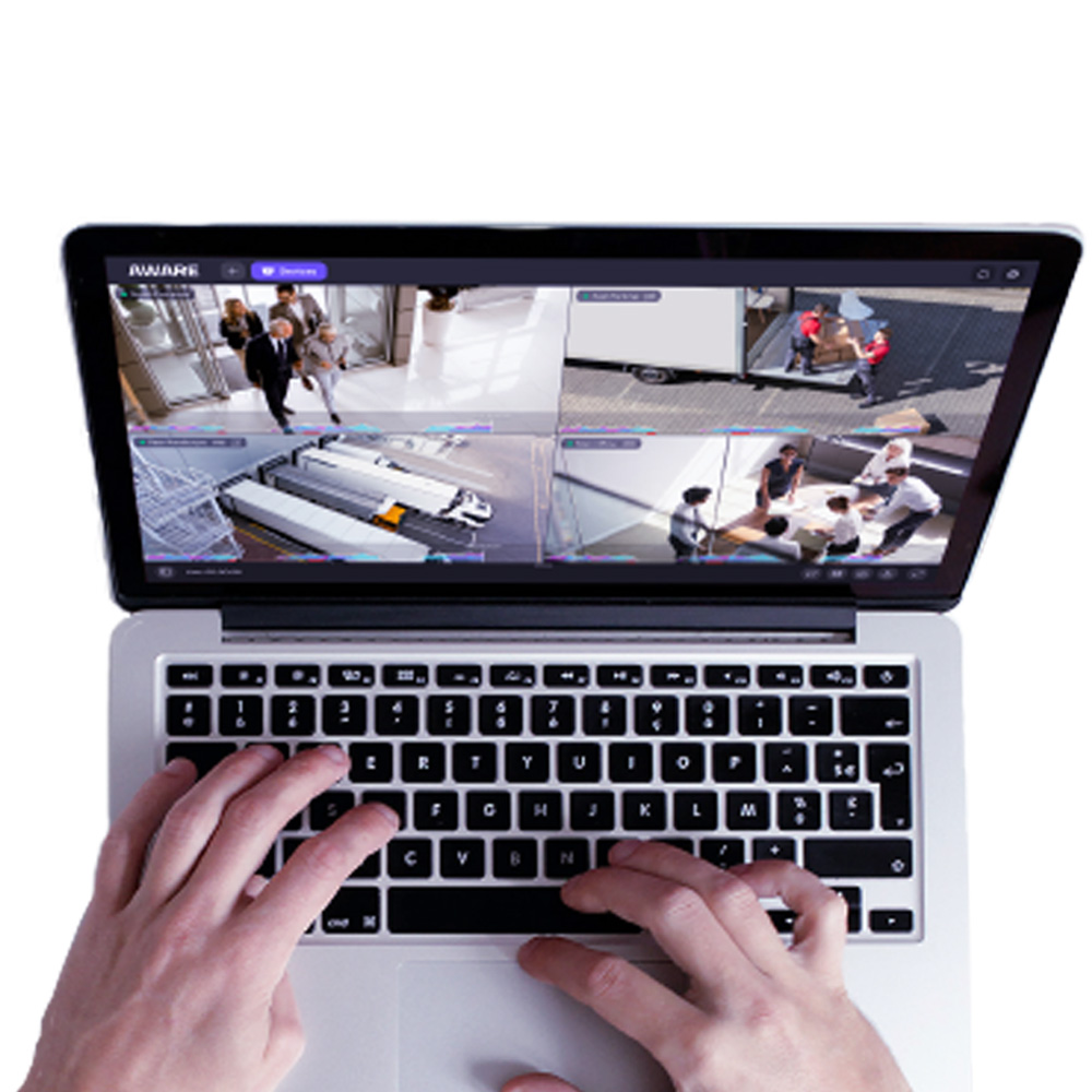 Ein Laptop, der Sicherheitskameraaufnahmen in mehreren Fenstern auf dem Bildschirm zeigt; eine Person tippt auf der Tastatur.