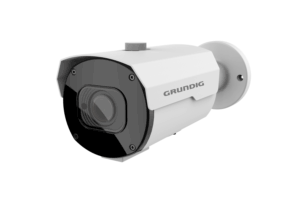 Eine weiße Überwachungskamera von Grundig mit einem schwarzen Frontbereich und einer Linsenabdeckung, seitlich angebracht an einer Wandhalterung.