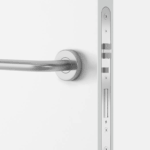 Silberne Türgriff und Schloss auf einer weißen Tür, mit einem runden Rosettengriff und einem modernen, schlanken Design.