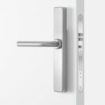 Eine silberne Türgriffgarnitur an einer weißen Tür, mit einem modernen, minimalistischen Design.