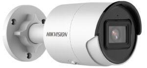 Eine weiße Überwachungskamera der Marke Hikvision, montiert an einer Wandhalterung, mit einem schwarzen Schutzschild um das Objektiv.