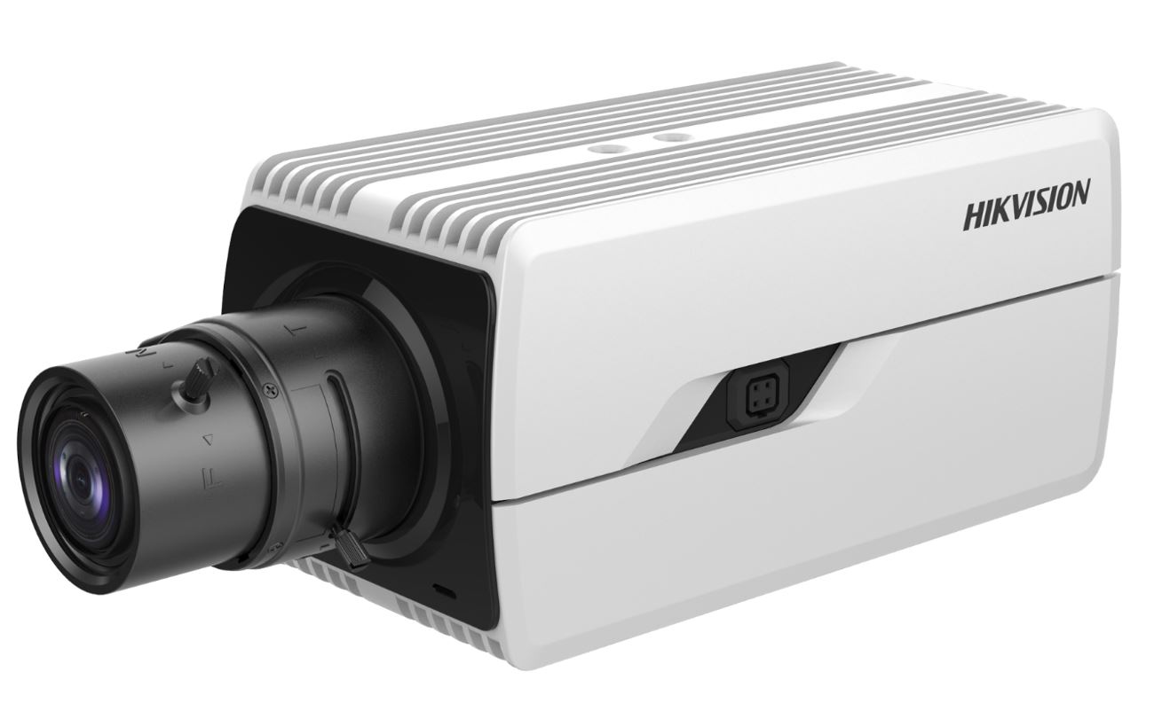 Nahaufnahme einer weißen Überwachungskamera mit einem schwarzen Objektiv, seitlicher Markenname erkennbar.