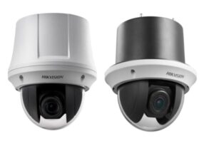 Zwei Überwachungskameras der Marke Hikvision, links in Weiß und rechts in Schwarz-Grau, mit abgerundeten Gehäusen und sichtbaren Objektiven an der Unterseite.