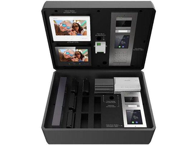 Ein offener schwarzer Koffer mit verschiedenen elektronischen Geräten, darunter zwei kleine Bildschirme mit Familienfotos, ein Bedienfeld mit Zahlen und einige Module und Netzwerkkästchen. Das Innere ist in Fächer unterteilt, um die Geräte sicher zu halten.