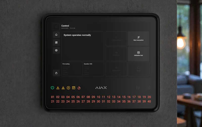 Ein schwarzes Display mit der Aufschrift "System operates normally" zeigt ein Kontrollpanel für ein Sicherheitssystem auf einer grauen Wand. Das Panel besitzt unten leuchtende Symbole und Nummern 01 bis 40 in roter Farbe.