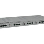 Ethernet-Switch mit mehreren Ports und Beschriftungen auf der Vorderseite in grauem Gehäuse.