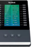 Ein Telefon-Addon von Yealink mit mehreren Tasten und einem Display, das Kontaktnamen und Nummern anzeigt.