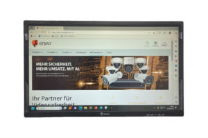 Ein Monitor zeigt eine Webseite von eneo mit Werbematerial für Überwachungskameras und dem Slogan "Mehr Sicherheit. Mehr Umsatz. Mit AI".