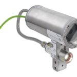 Industriekamera mit Metallgehäuse und grünem Kabel, geeignet für robuste Umgebungen.