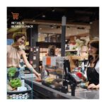 Eine Kunde lächelt, während sie an der Supermarktkasse bedient wird; ihr Einkaufswagen ist mit frischen Lebensmitteln gefüllt.