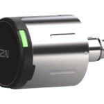 Ein runder, silberner Autozubehörstecker mit einem schwarzen Ende und einem leuchtenden grünen Indikator.