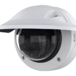 Weiße Überwachungskamera mit Kuppelgehäuse und Blendschutz, montiert gegen eine Wand.