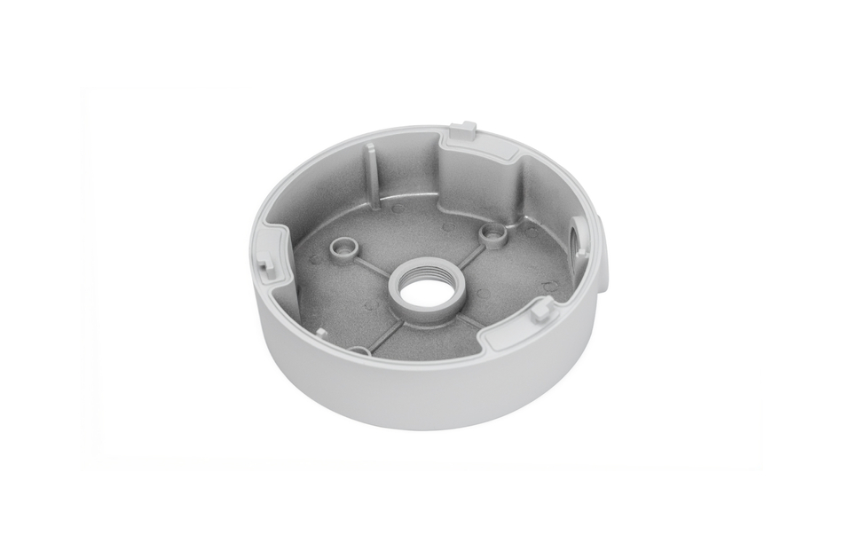 Ein runder, grauer, flacher Metallbehälter mit einer mittleren Öffnung und mehreren inneren Wänden.