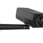 Schwarze Überwachungskamera auf einer Wandhalterung montiert, mit einem großen Objektiv.