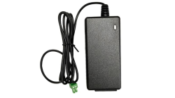 Ein schwarzes Netzteil mit einem langen Kabel und einem grünen Stecker am Ende.