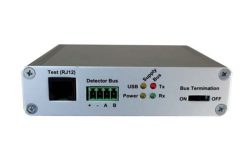 Ein silbernes elektronisches Gerät mit RJ12-Testanschluss, Detektorbus, USB-Leuchten, Bus-Terminationsschalter und weiteren Anschlussmöglichkeiten.