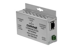 Ein silbernes elektronisches Gerät mit der Aufschrift "comnet COMMUNICATION NETWORKS", das über Ethernet- und erweiterte Distanzanschlüsse verfügt. Es scheint ein Netzwerkgerät zu sein.