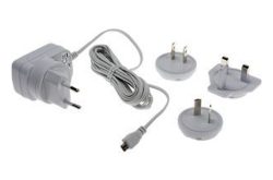 Ein weißes Netzteil mit Kabel und vier austauschbaren Steckern für verschiedene Steckdosenstandards.