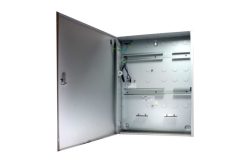 Ein offener, leerer Verteilerkasten aus Metall mit sichtbaren Kabeln, in einem hellen Raum.