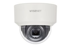 Eine weiße Überwachungskamera mit der Aufschrift "WISENET", die ein schwarzes Kameraobjektiv in einer durchsichtigen Kuppel zeigt.