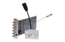Ein elektronisches Gerät mit mehreren Koaxialanschlüssen und einem Kabel, das an ein weißes Modul angeschlossen ist.