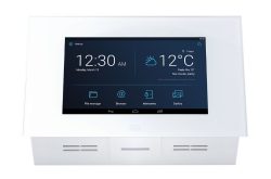 Ein weißes Smart-Home-Display zeigt die Uhrzeit 12:30 AM, das Datum Montag, 13. März, und das Wetter in Prag mit 12°C, teilweise bewölkt und sonnig. Unten sind Symbole für Dateimanager, Browser, Gegensprechanlagen und Galerie.