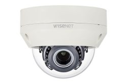 Eine weiße Überwachungskamera von Wisenet in einer kuppelförmigen Ausführung mit sichtbarem Kameraobjektiv im Inneren.