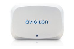 Ein weißes Gerät von Avigilon mit abgerundeten Ecken und einem kleinen blauen Punkt unten in der Mitte.