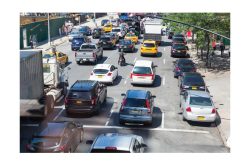 Verkehrsstau auf einer mehrspurigen Straße in der Stadt, mit Autos und Taxis.