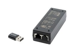 Ein schwarzer Netzwerkadapter mit zwei Ethernet-Anschlüssen und einem USB-Dongle daneben. Auf der Oberseite des Geräts befinden sich technische Informationen.