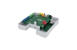 Ein grünes elektronisches Gerät in einem weißen Gehäuse mit bunten Anschlüssen.