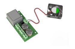 Elektronische Schaltung mit Kondensatoren auf grüner Platine und angeschlossenem kleinen Ventilator.