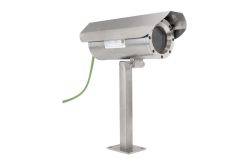 Eine Überwachungskamera aus Edelstahl mit einem zylindrischen Gehäuse auf einer Stange montiert, mit einem grünen Kabel verbunden.