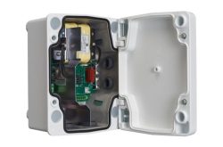 Geöffnete Kunststoffbox mit elektronischen Komponenten im Inneren, darunter eine Platine und Kabel.