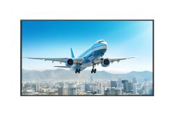 Passagierflugzeug im Landeanflug über einer Stadt vor einer Bergkulisse