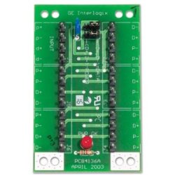 Elektronische Leiterplatte mit der Aufschrift 'GE Interlogix', mehreren Anschlusskontakten auf jeder Seite und einem roten Knopf in der Mitte.