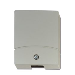 Ein weißes, rechteckiges Gehäuse mit einem zentralen Schraubverschluss an der Vorderseite, vermutlich ein elektrisches oder technisches Bauteil.