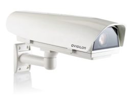 Eine weiße Überwachungskamera der Marke Avigilon mit rechteckigem Gehäuse, an einer Wandhalterung montiert.